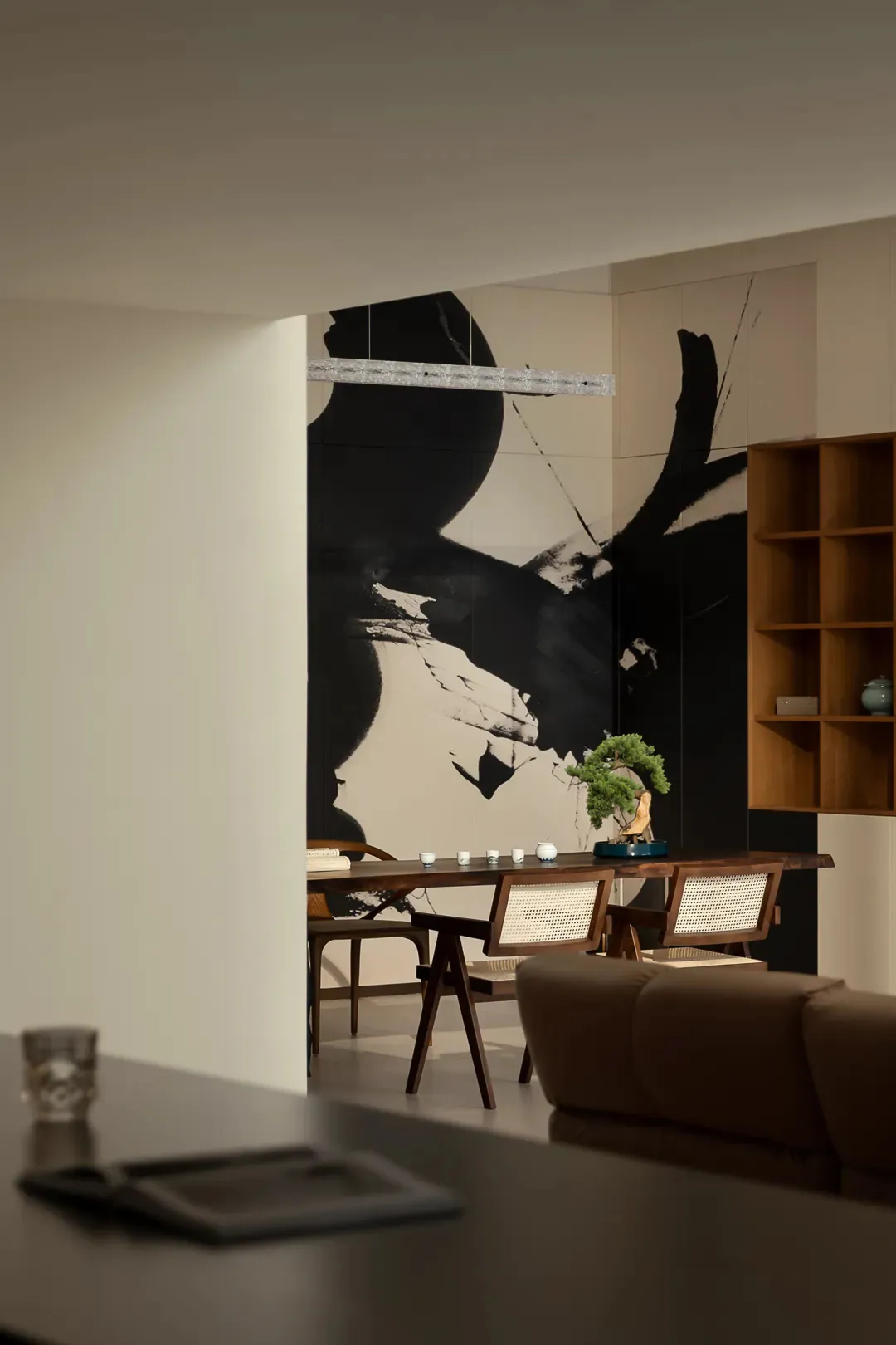 Modern living room featuring wooden furniture, minimalist decor, and a large abstract mural on the wall.