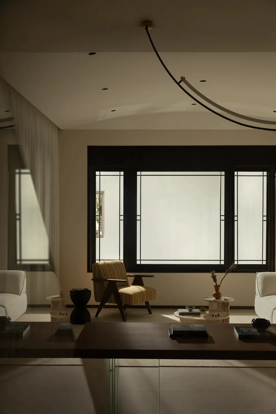 A minimalist living room with wooden elements and large windows.