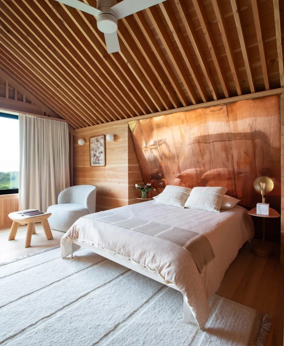 A modern minimalist bedroom featuring wood elements and a white bed.