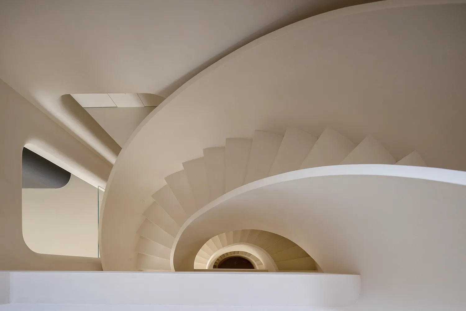 A modern, minimalist interior design featuring a white spiral staircase with clean lines and a sleek, contemporary aesthetic.