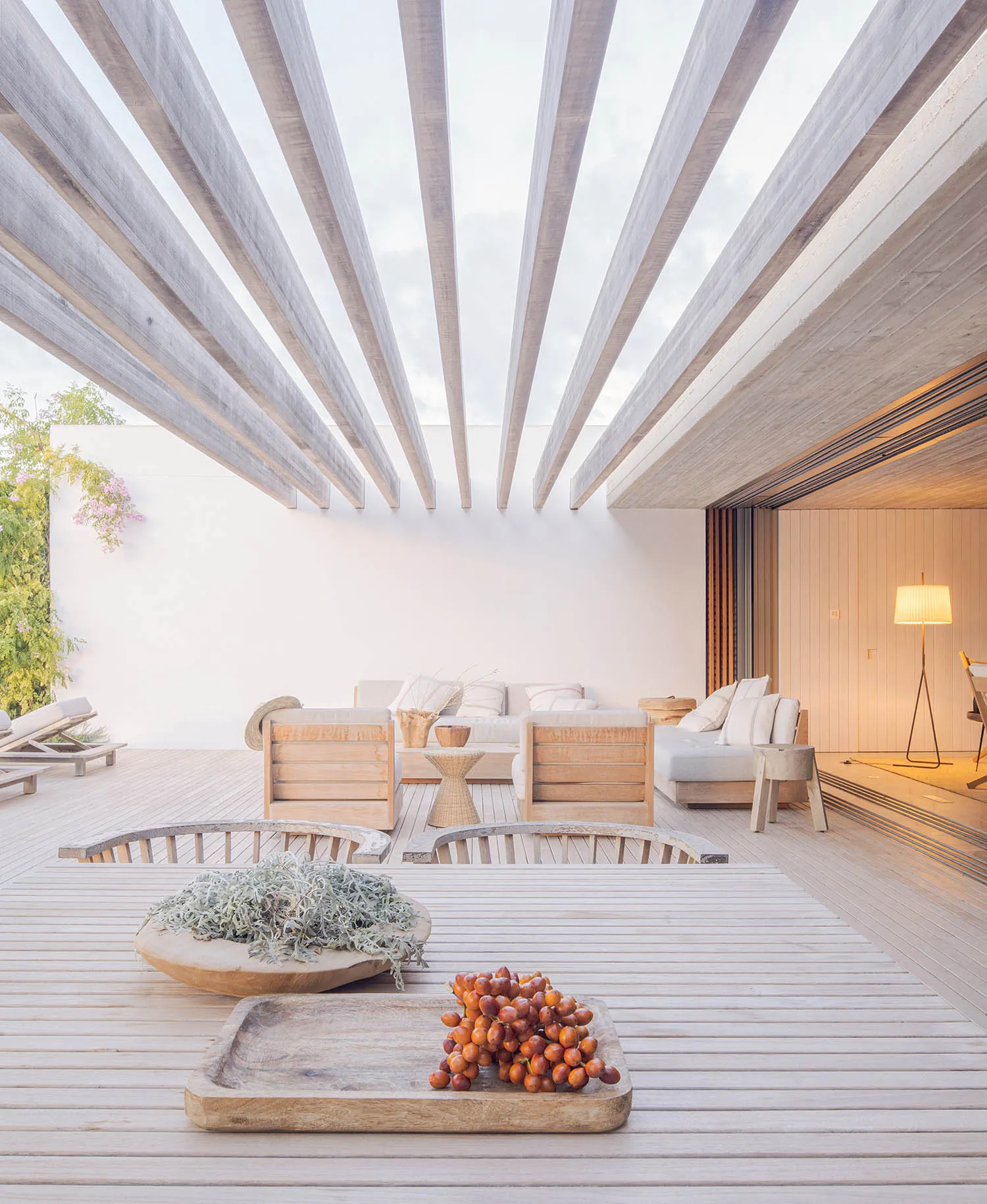 Modern patio with wooden furniture and a skylight ceiling.