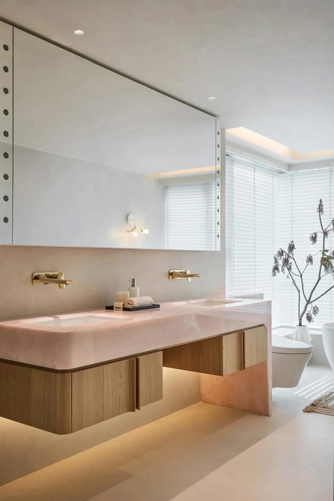 現代極簡浴室，設有粉紅大理石雙洗手台、木質櫃體、黃銅五金，以及大型窗戶