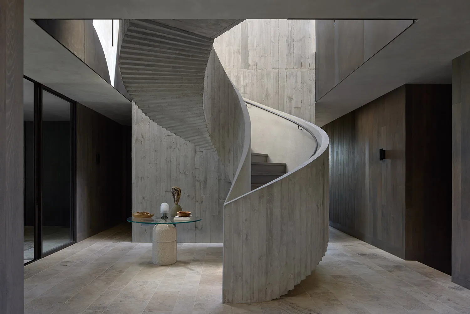 Interior view of a modern industrial staircase with concrete walls and floor.