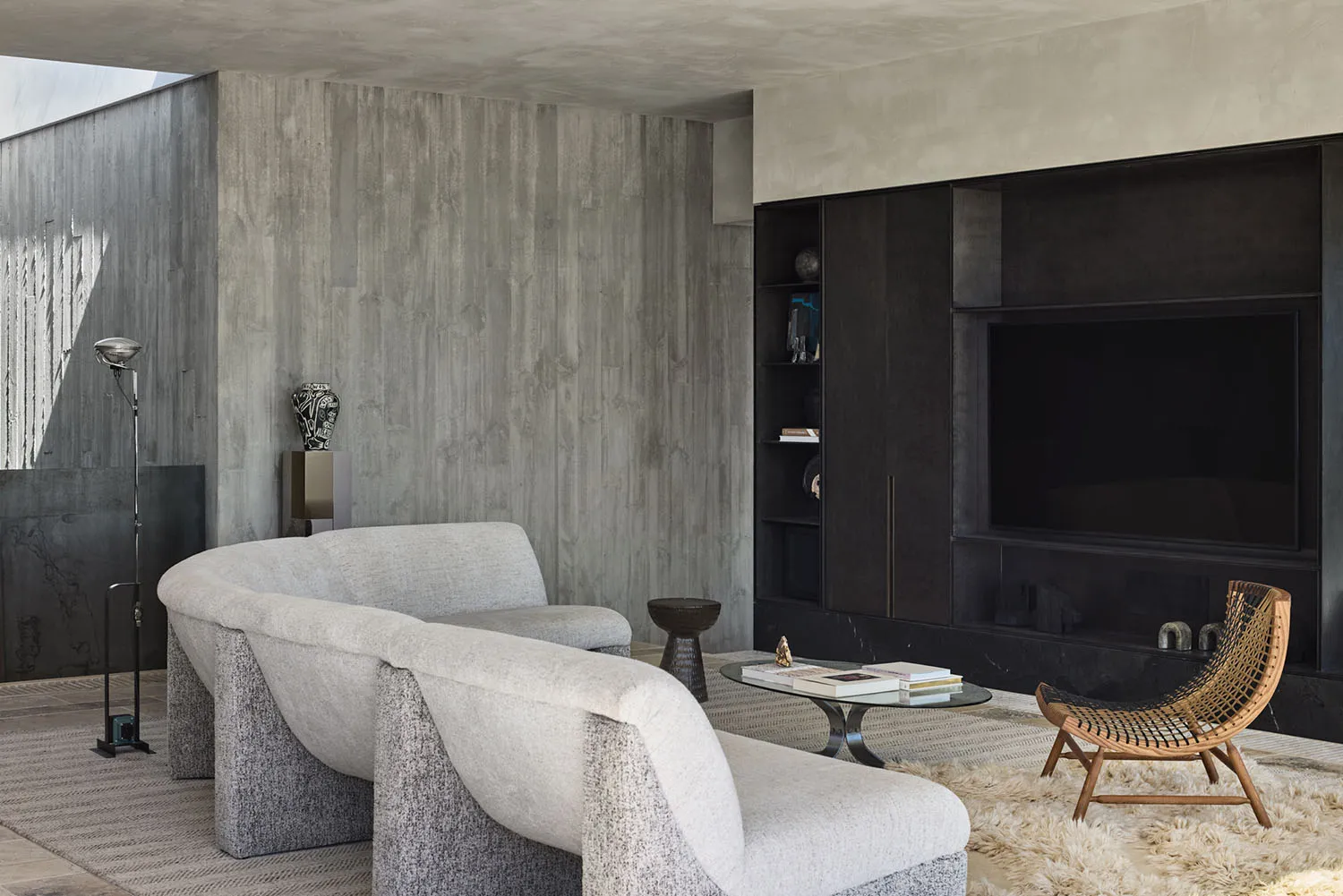 A modern living room with a concrete wall and floor.