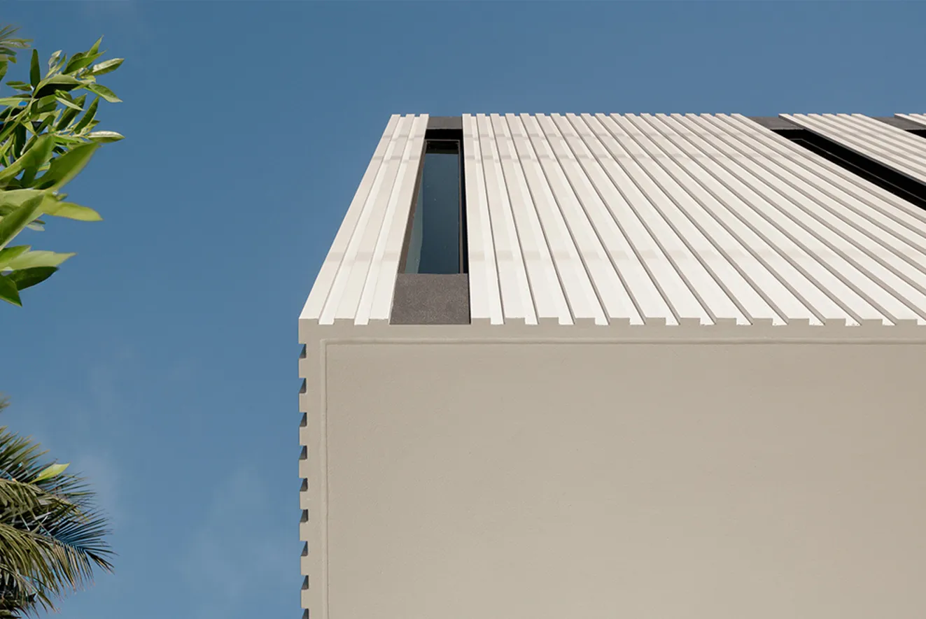 A modern building with a metallic roof and narrow windows.