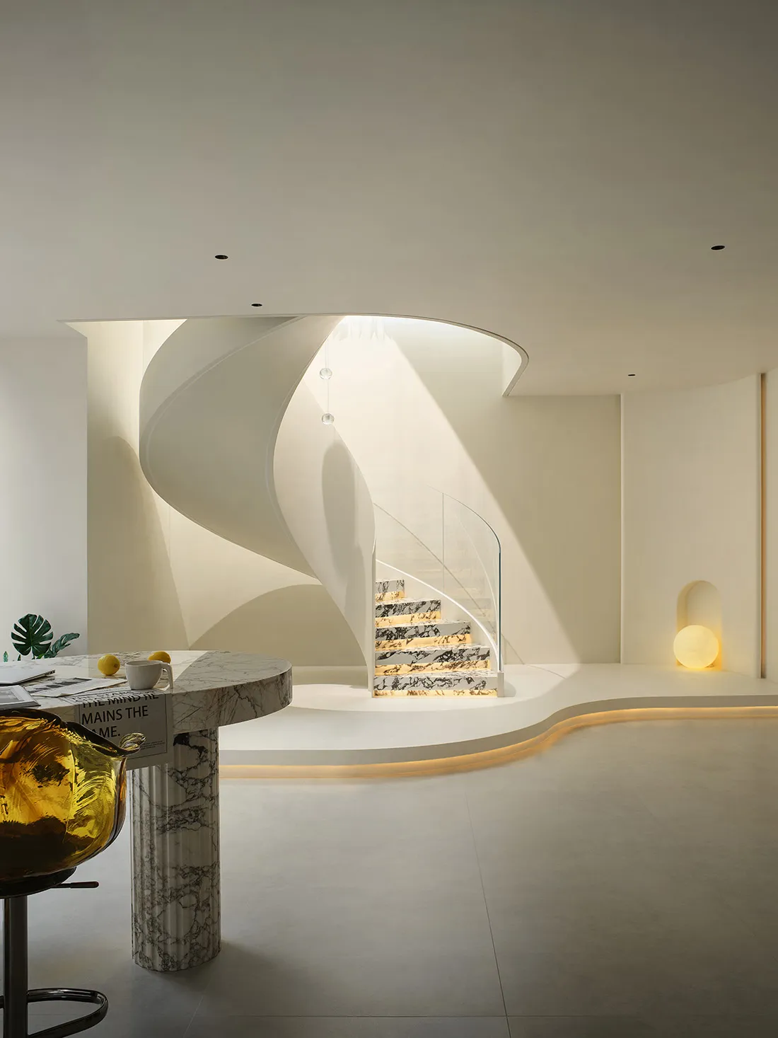 A modern minimalist interior with a spiral staircase and glass railing, featuring marble steps.
