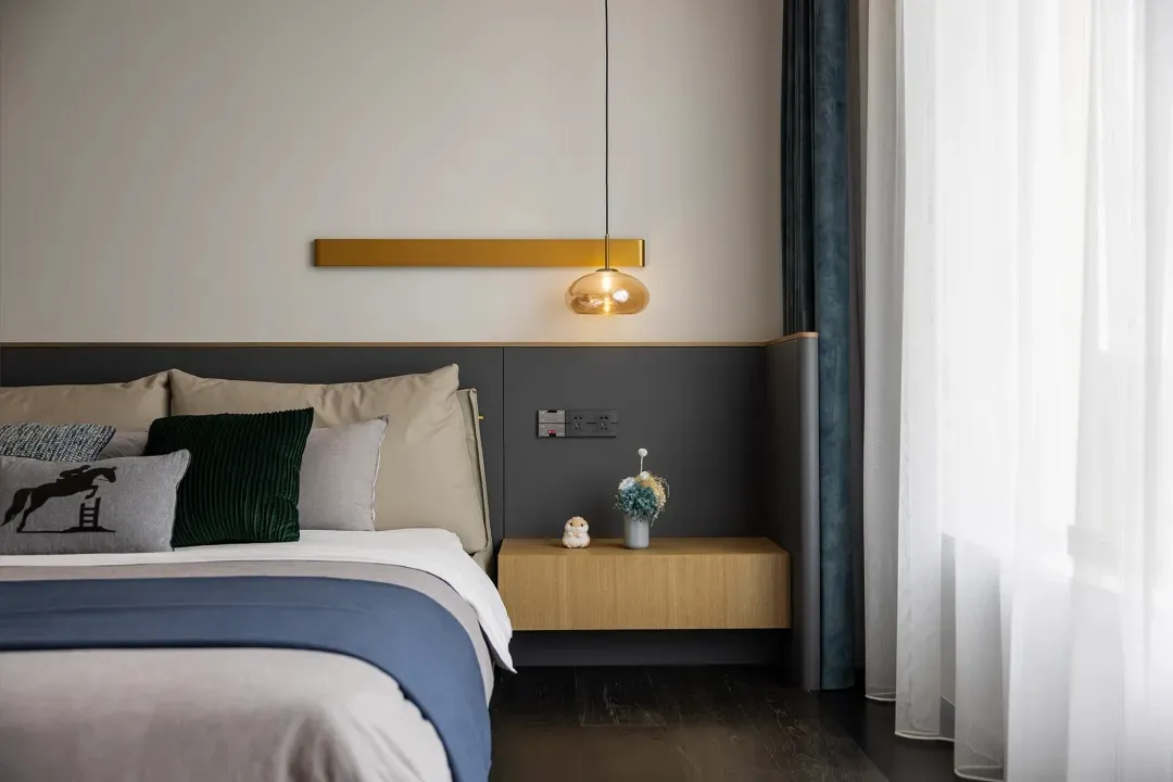 Modern bedroom featuring a bed with fabric and wood elements and a glass pendant light hanging above.