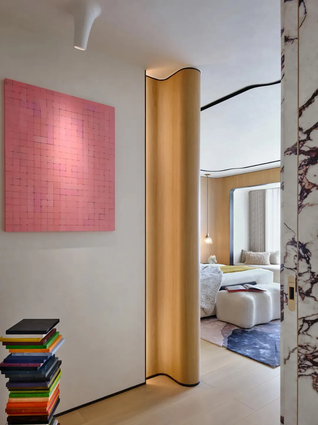 A modern bedroom with a wooden column and a pink abstract painting on the wall.