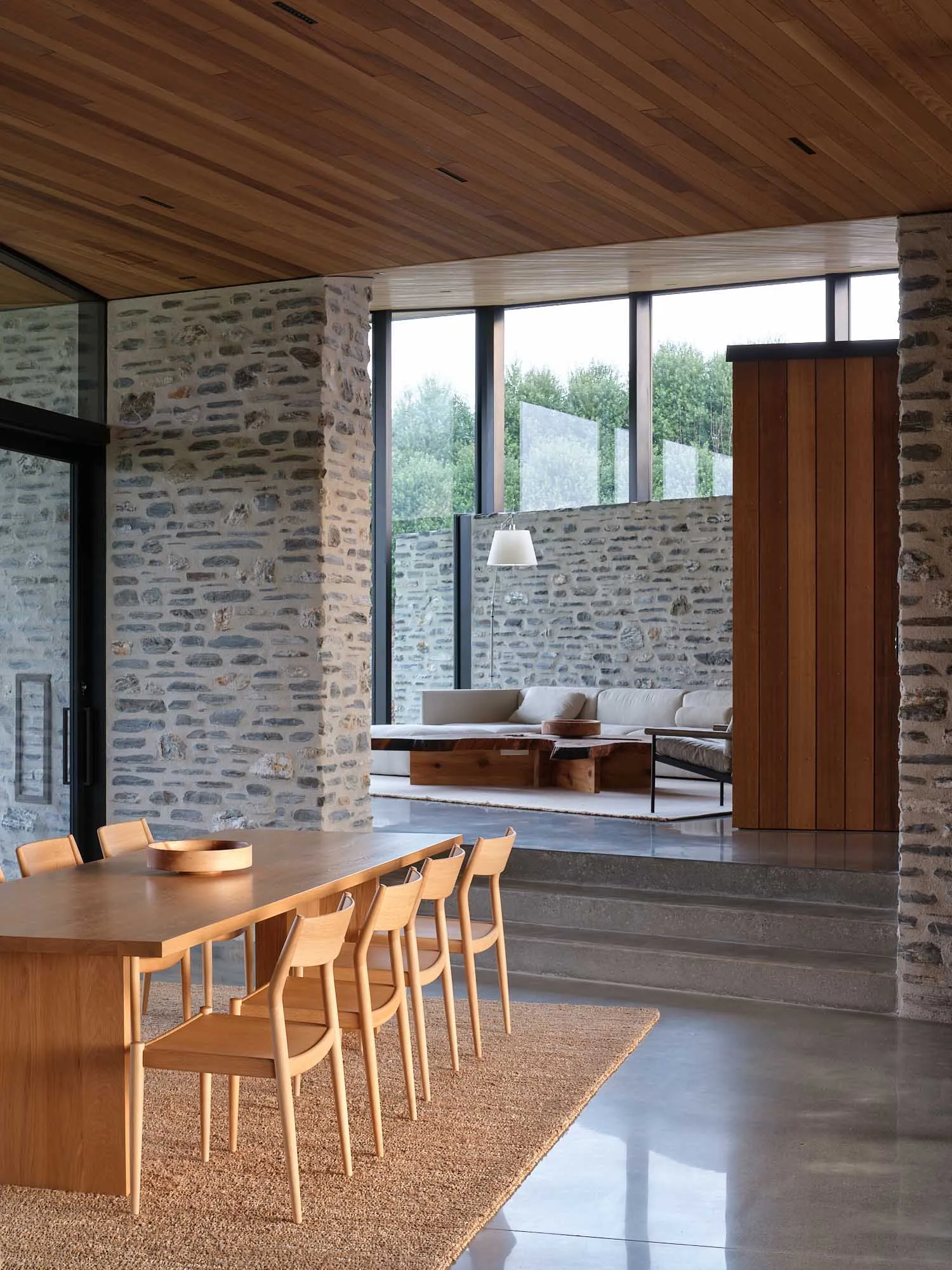 A modern living room with wooden furniture and concrete elements.