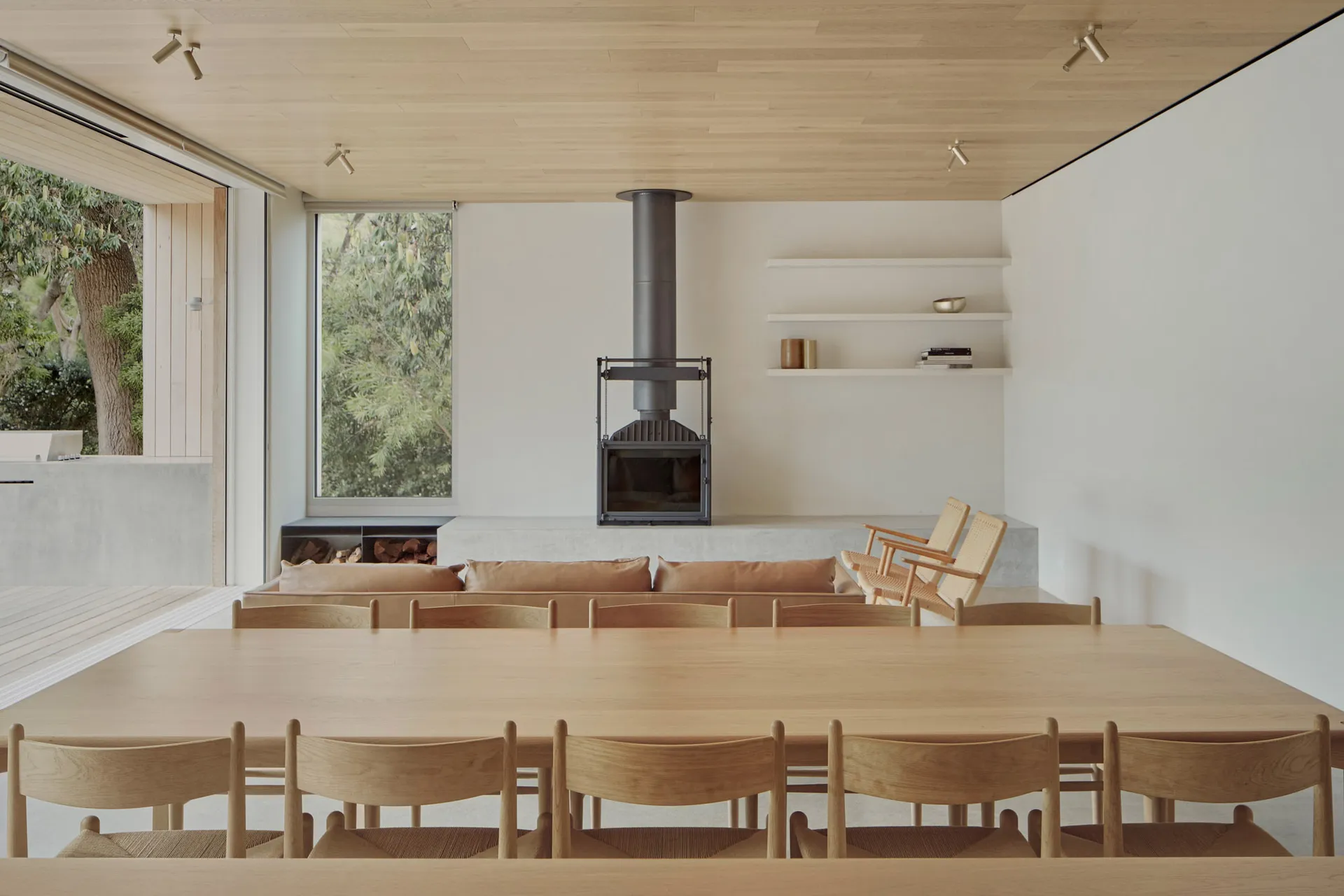 Minimalist residential interior featuring wood elements and a large floor-to-ceiling window.