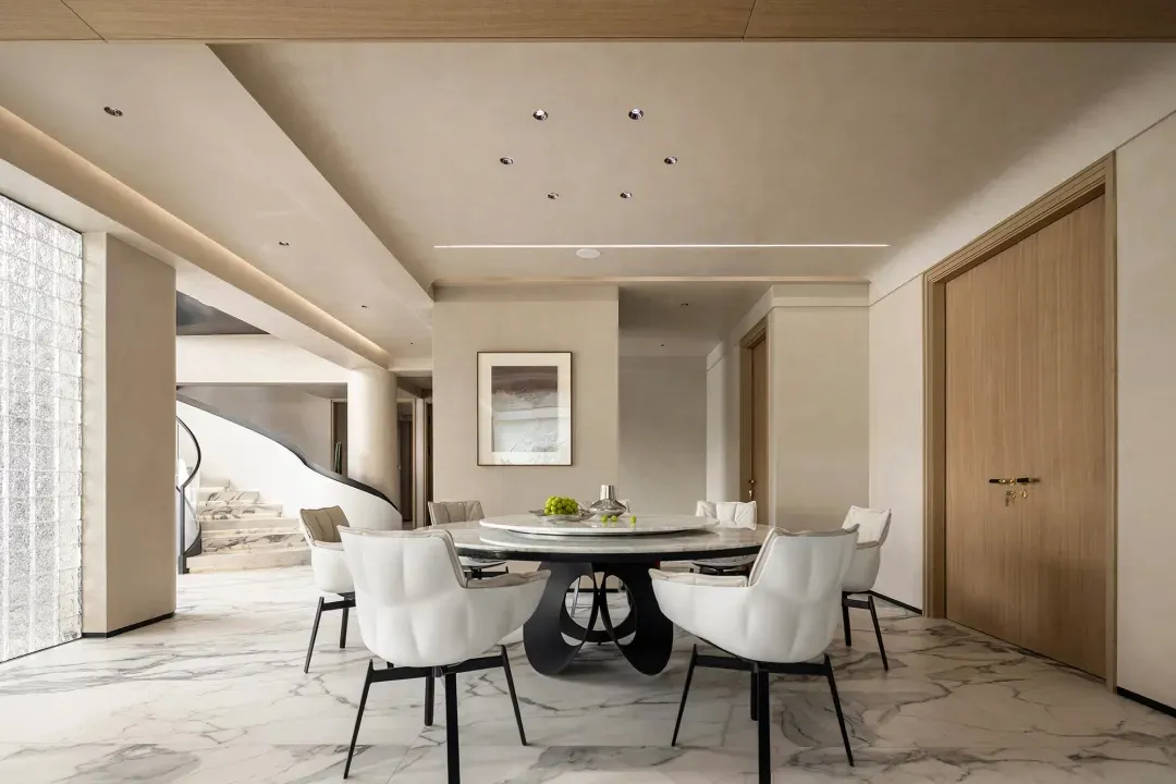 Modern dining room with marble table, white leather chairs, and black base