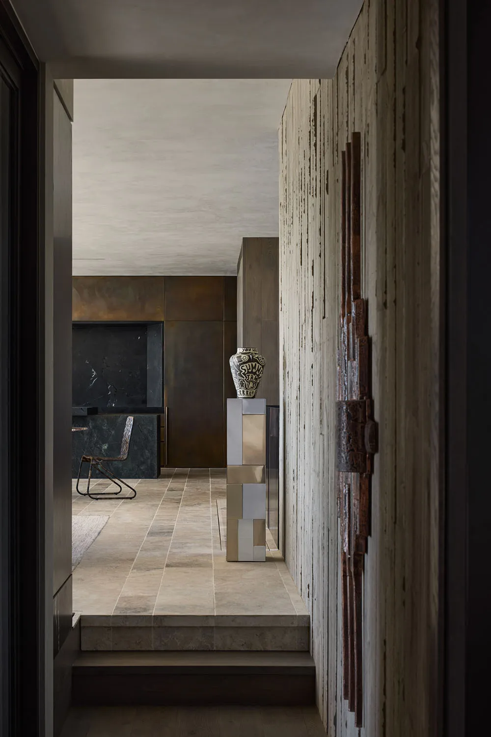 Modern interior corridor featuring metallic walls, wooden furniture, and concrete flooring.