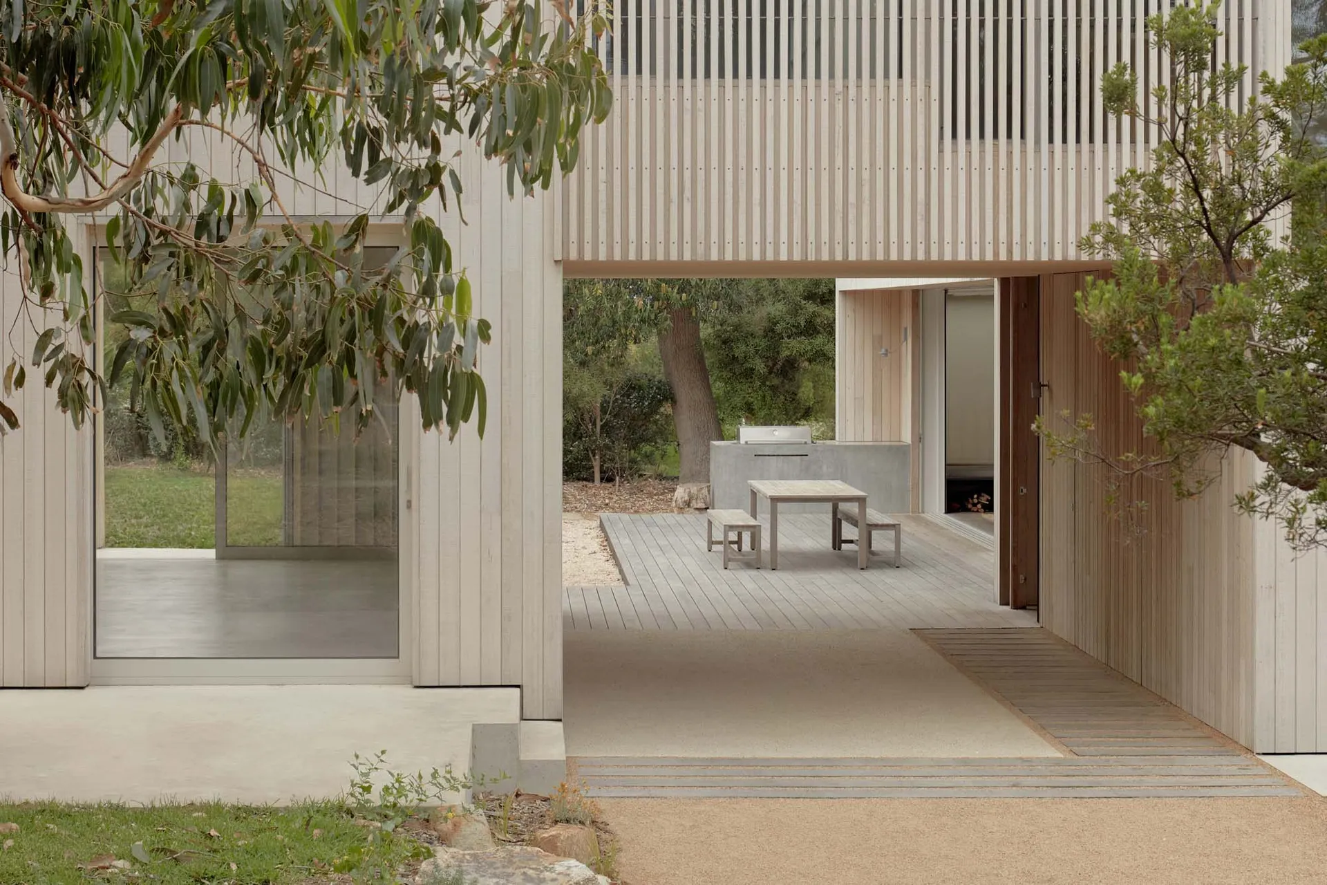 Modern residential exterior with wooden panels and concrete elements.
