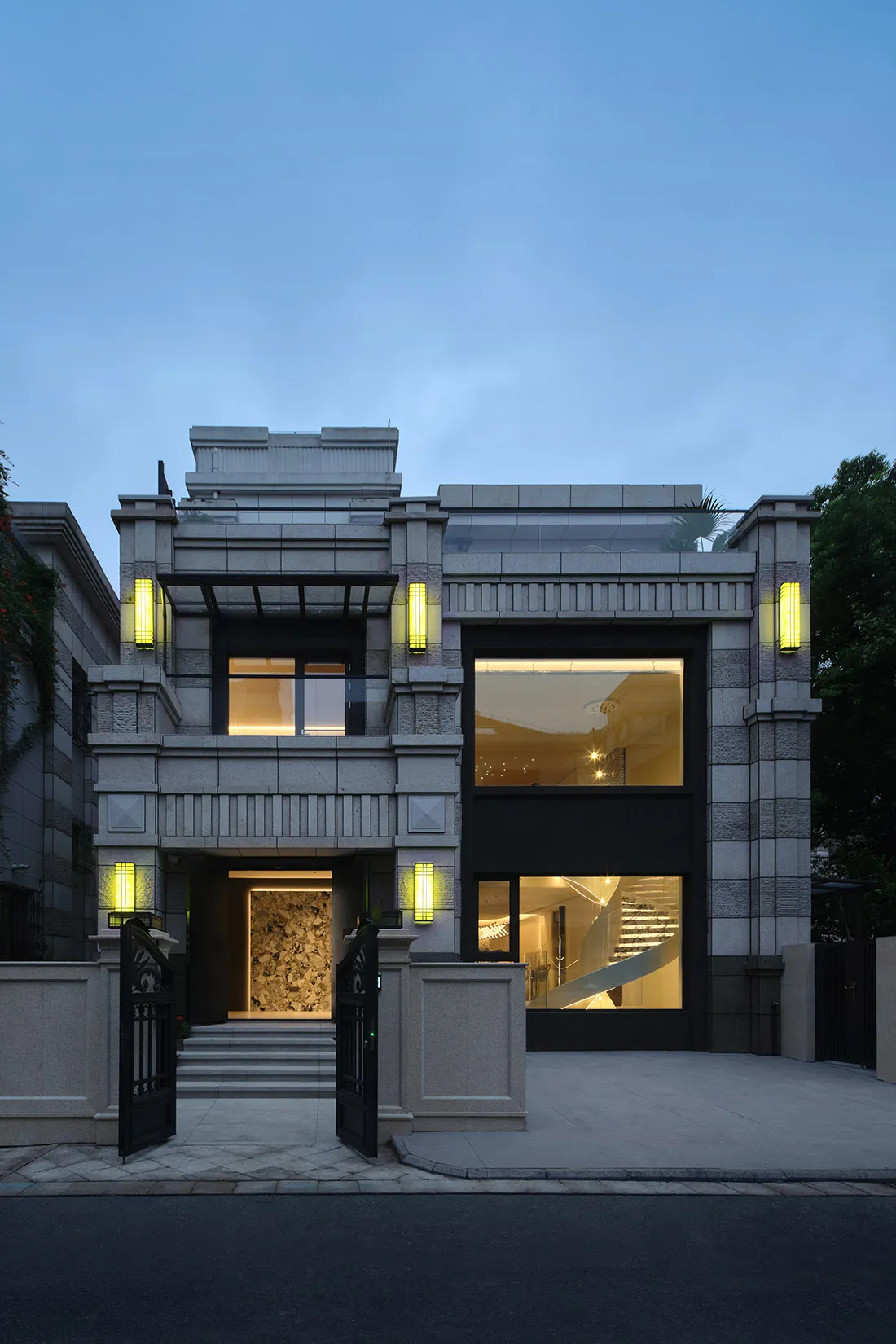 A modern residential home featuring concrete, glass, and stone materials.
