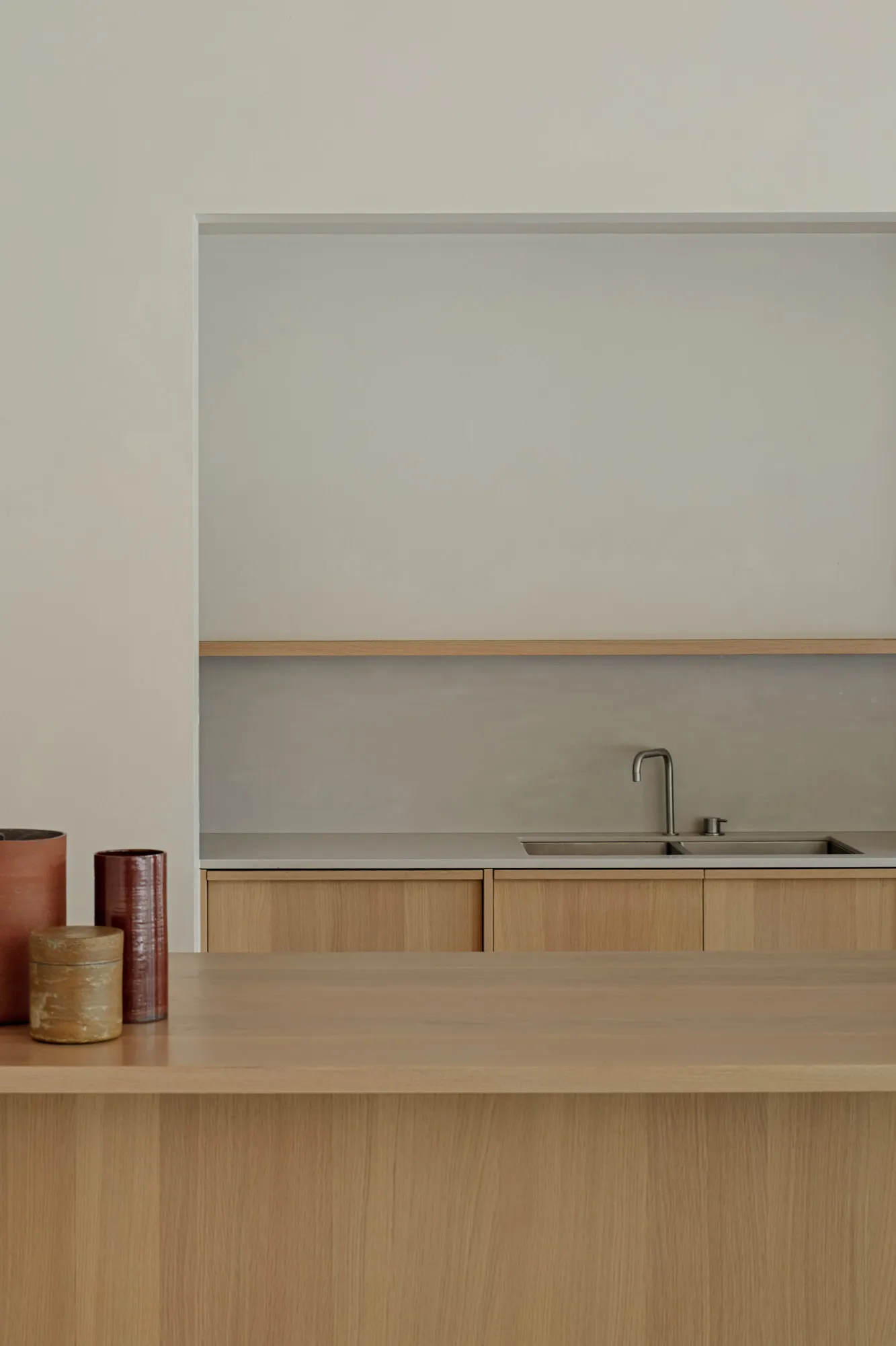 Modern minimalist kitchen featuring wood and concrete materials.