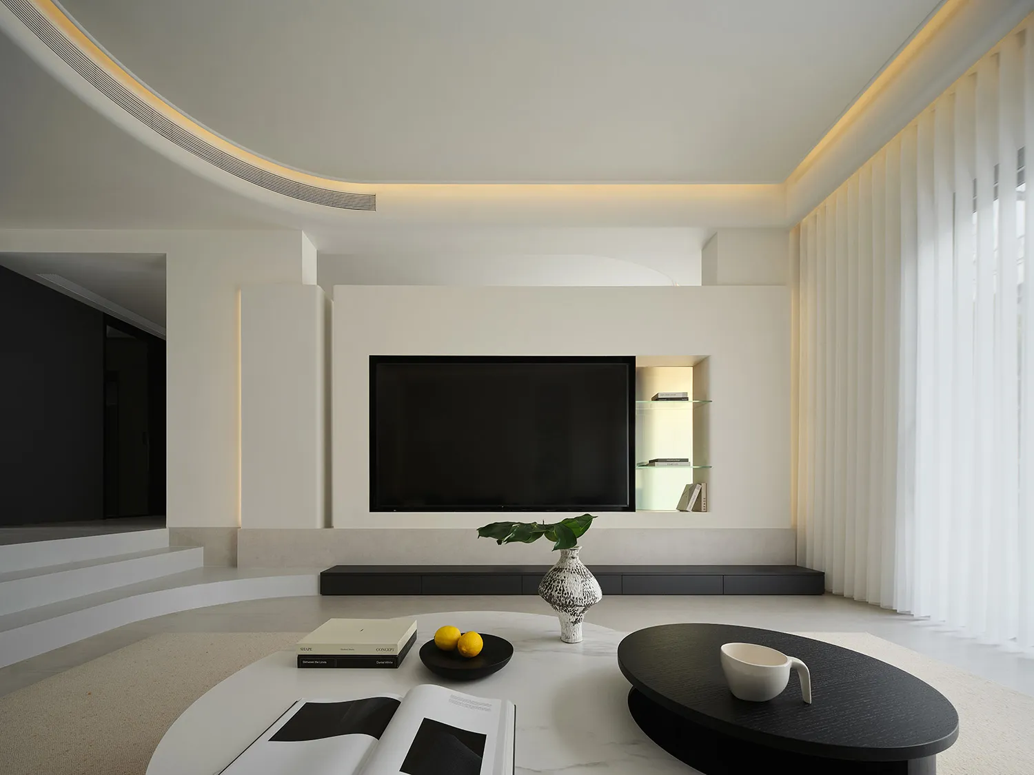 A modern minimalist living room with a large window, a white and black coffee table, and a white wall with a flat-screen TV.