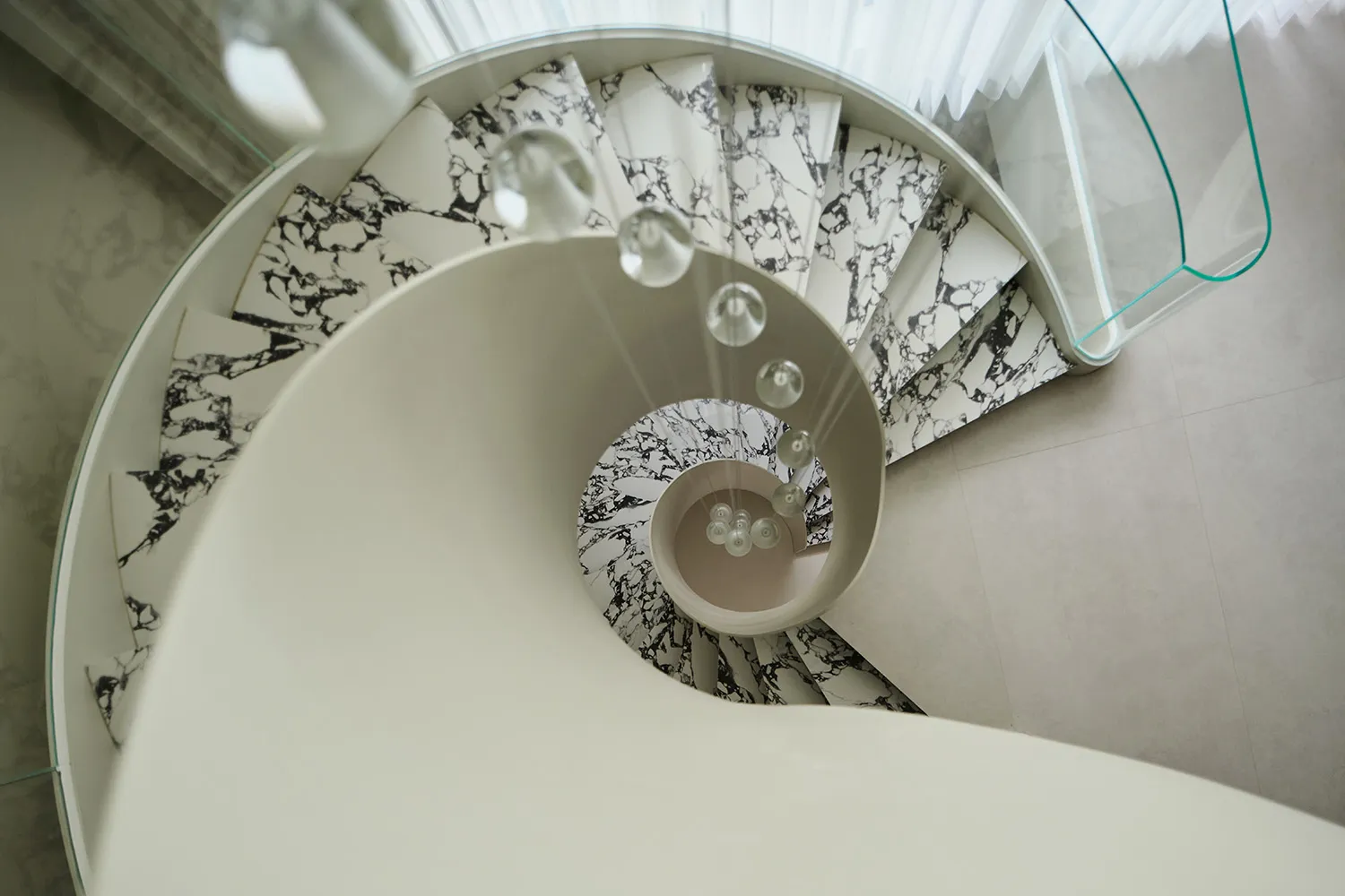 Circular staircase made of white and black marble materials.