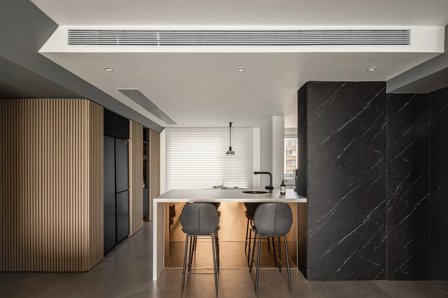 Modern kitchen interior featuring marble countertops and blackwood cabinets.