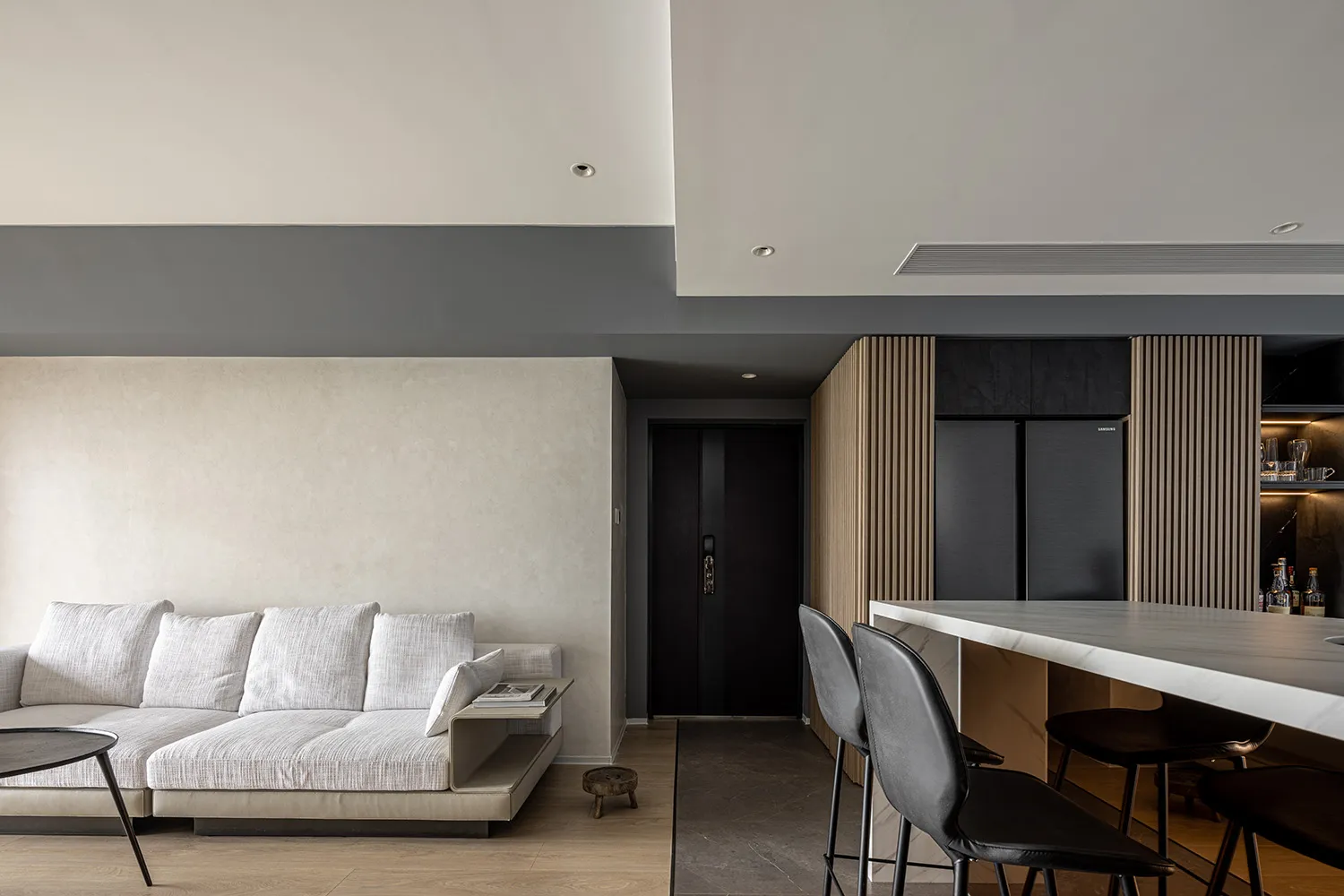Modern minimalist living room featuring a white L-shaped sofa, wooden floor, marble coffee table, and metal frame.
