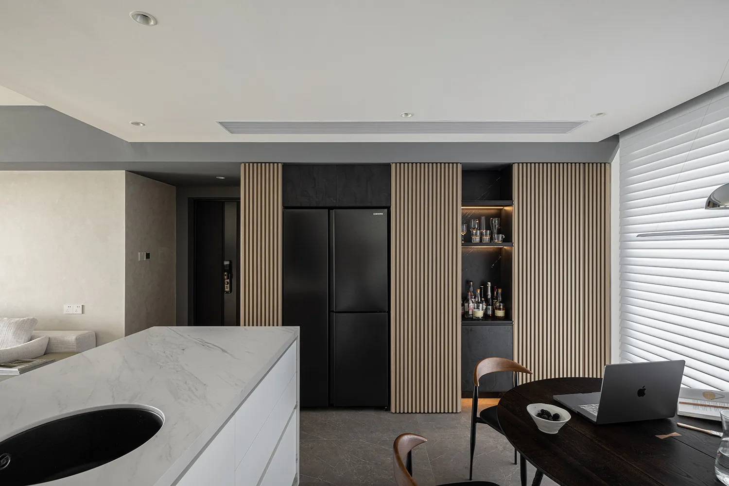 Modern residential kitchen featuring a marble countertop and black appliances.