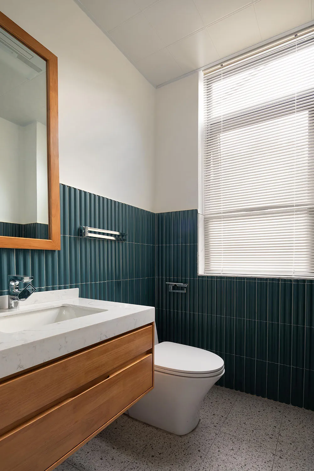 Modern bathroom interior with green tiles and wooden vanity.