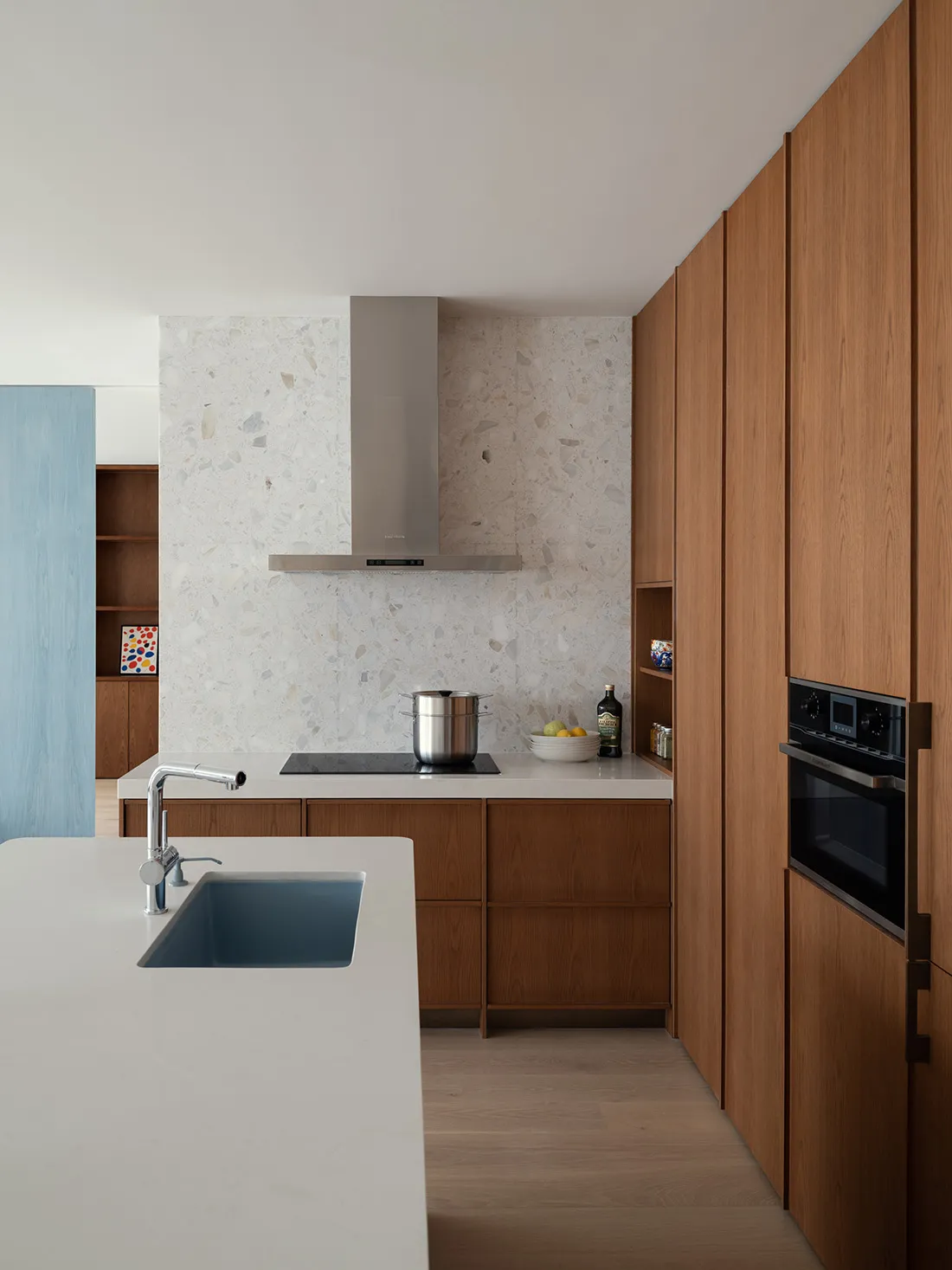 A modern residential kitchen with a white terrazzo countertop and minimalist design.