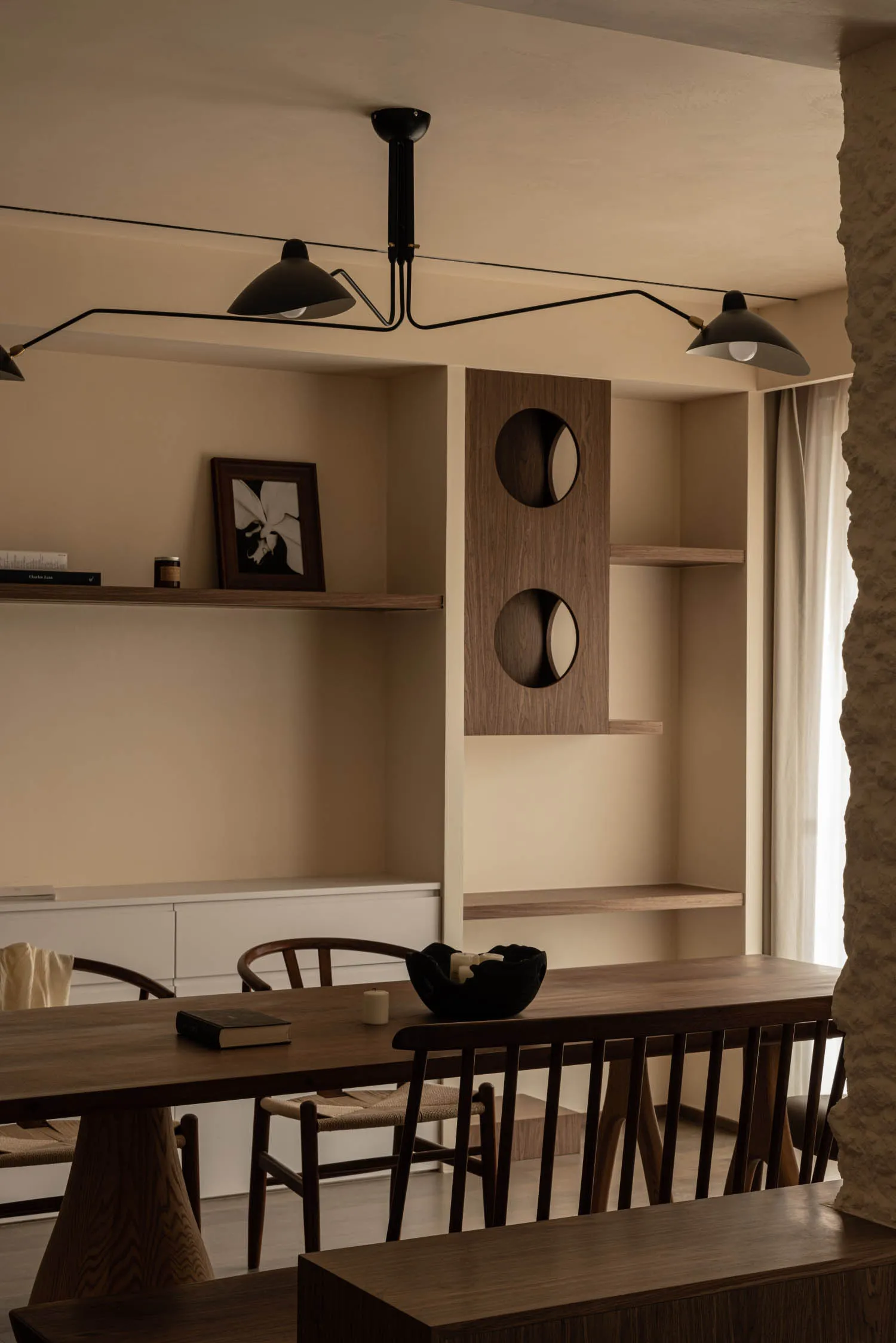 A modern minimalist dining room with wooden furniture and minimalist decor, featuring a long wooden table, chairs, and decora