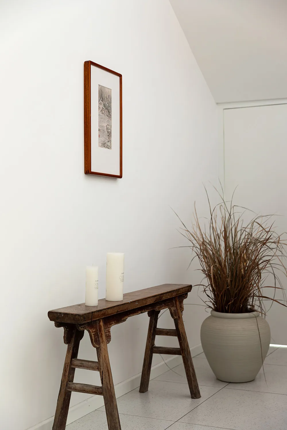 A minimalist space featuring natural wood furniture and ceramic elements.