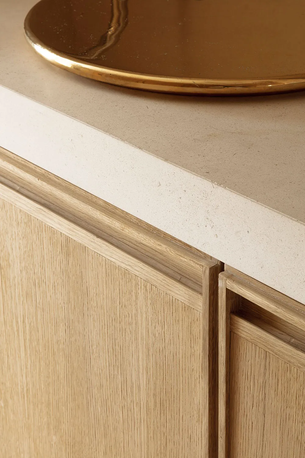 A minimalist interior space with a wooden cabinet and metallic tray on a concrete countertop.