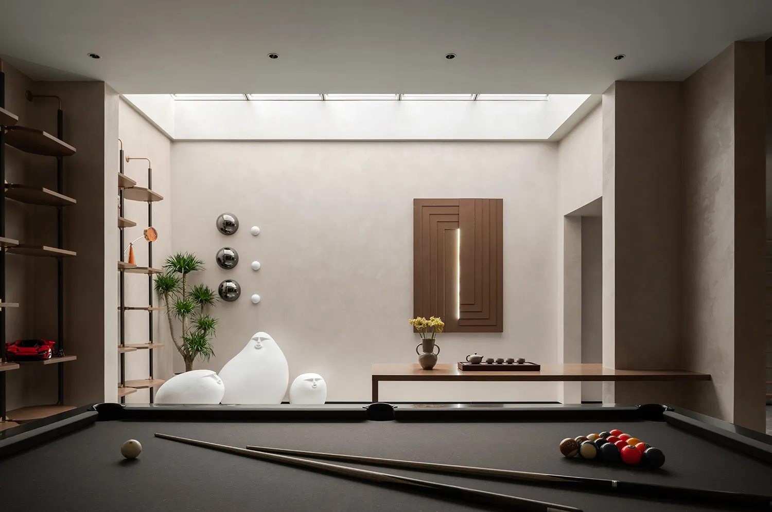 A modern living room featuring minimalist design with concrete walls, glass windows, and wooden accents.