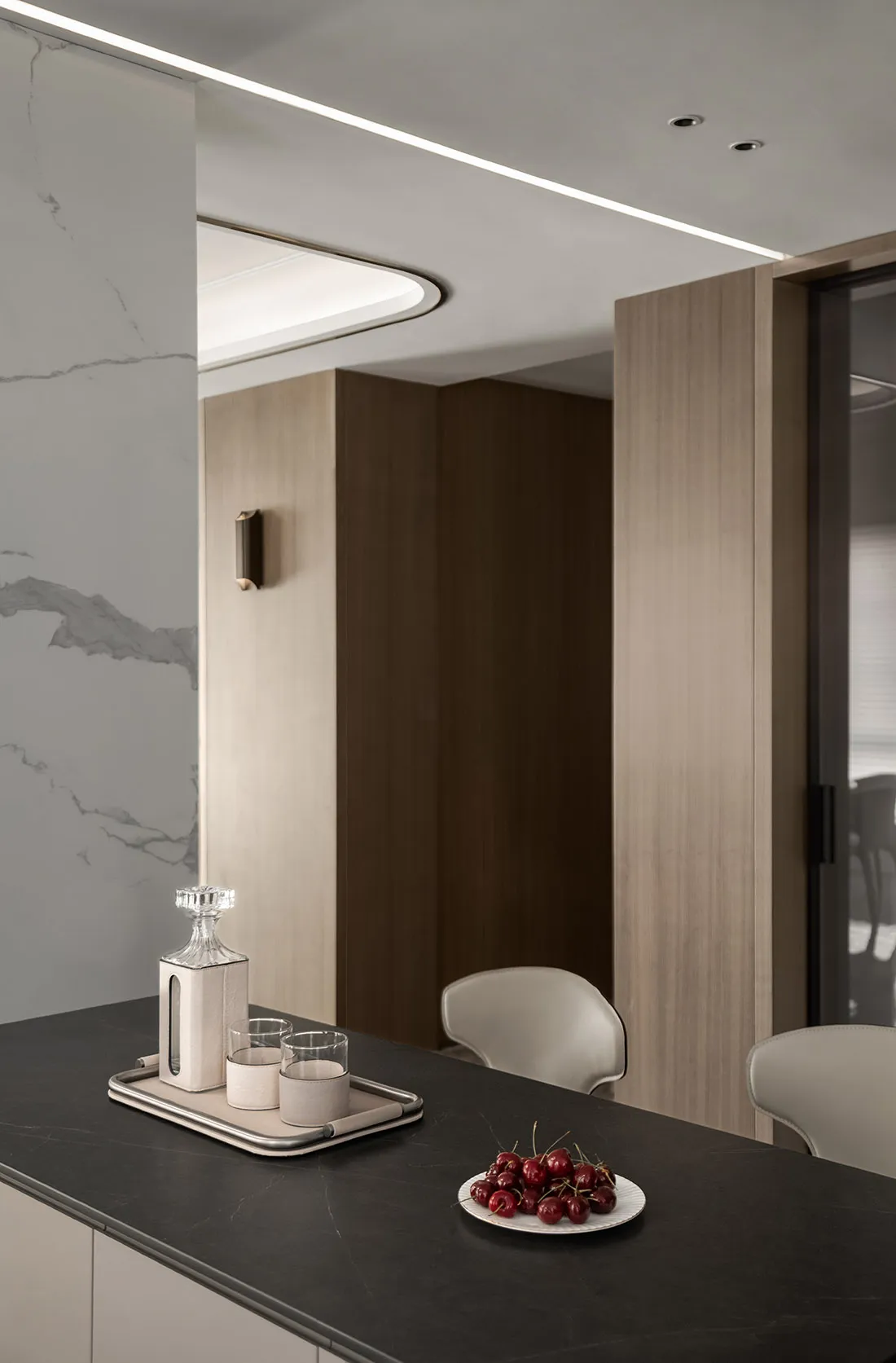 Modern minimalist kitchen featuring marble countertops and wooden cabinets.