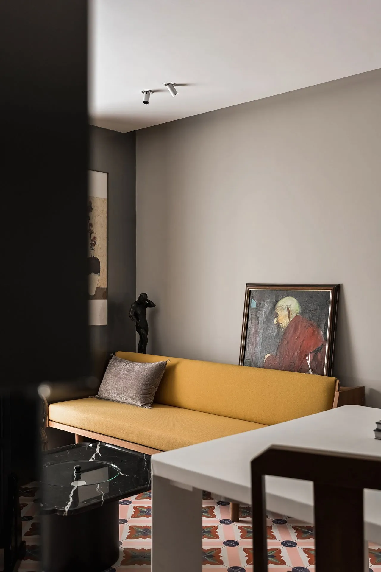 Modern living room featuring a yellow sofa, marble side table, and abstract wall art.