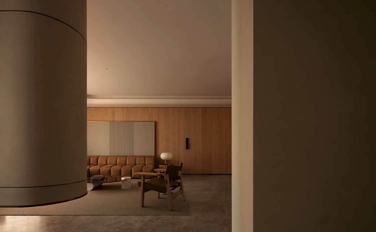 A minimalist living room featuring wooden flooring and furniture.