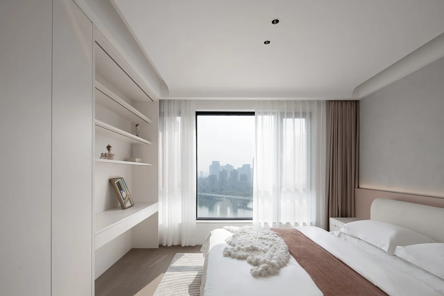 A modern minimalist bedroom featuring white fabric bedding and wooden elements.