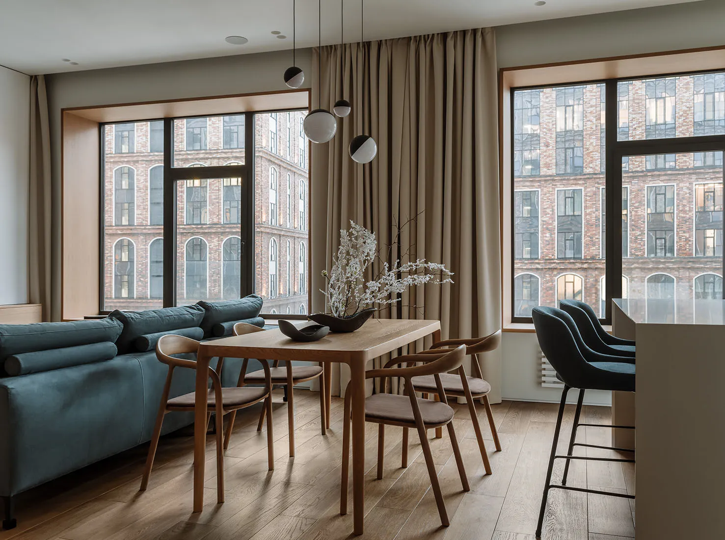 A modern minimalist dining room featuring wood furniture and glass windows.