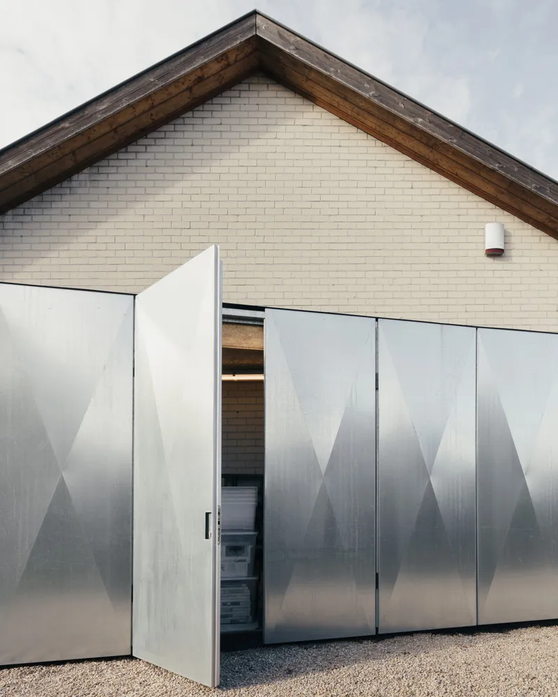 Modern building exterior featuring metallic panels and brick wall