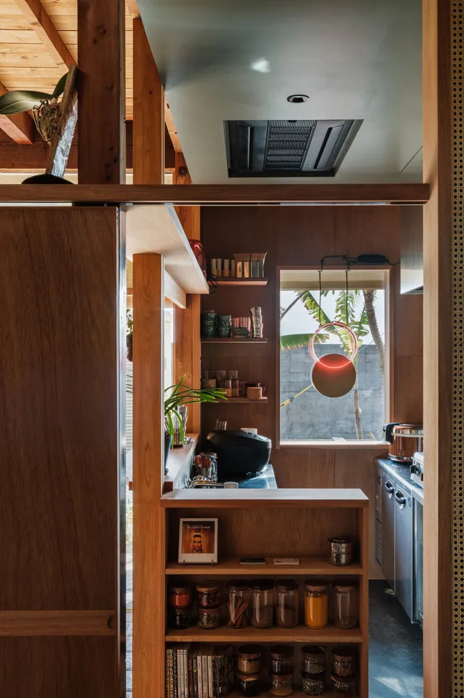A kitchen showcasing industrial design elements with wooden furniture and various storage solutions.