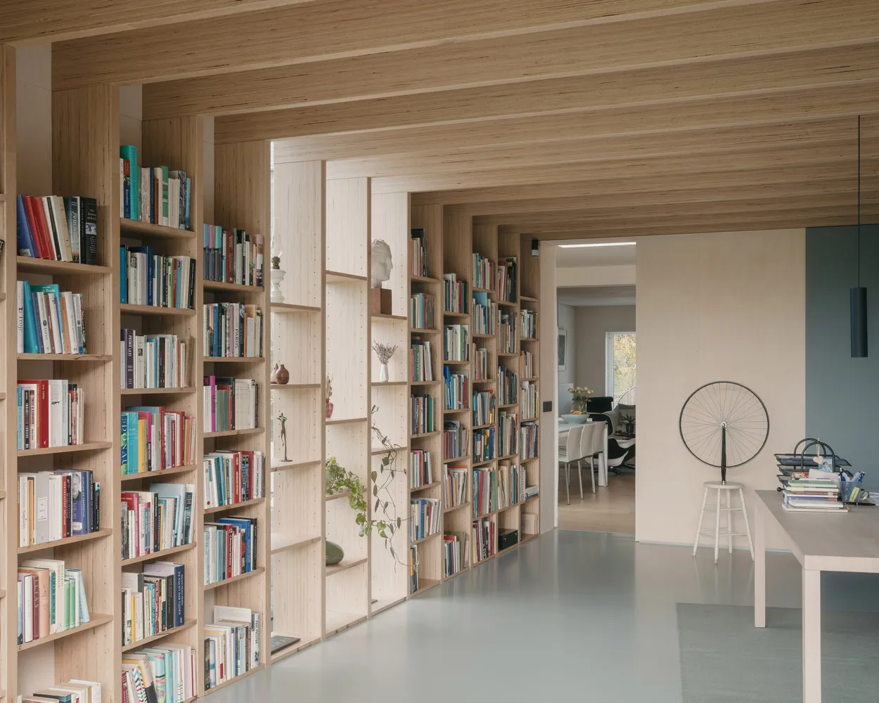 A modern library featuring wooden shelves filled with books and decorative items.