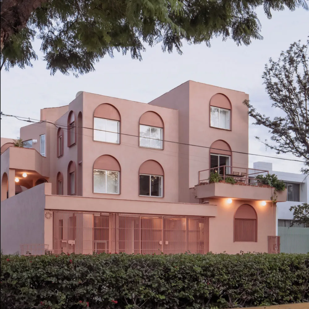 Modern residential building with concrete facade and arched windows.