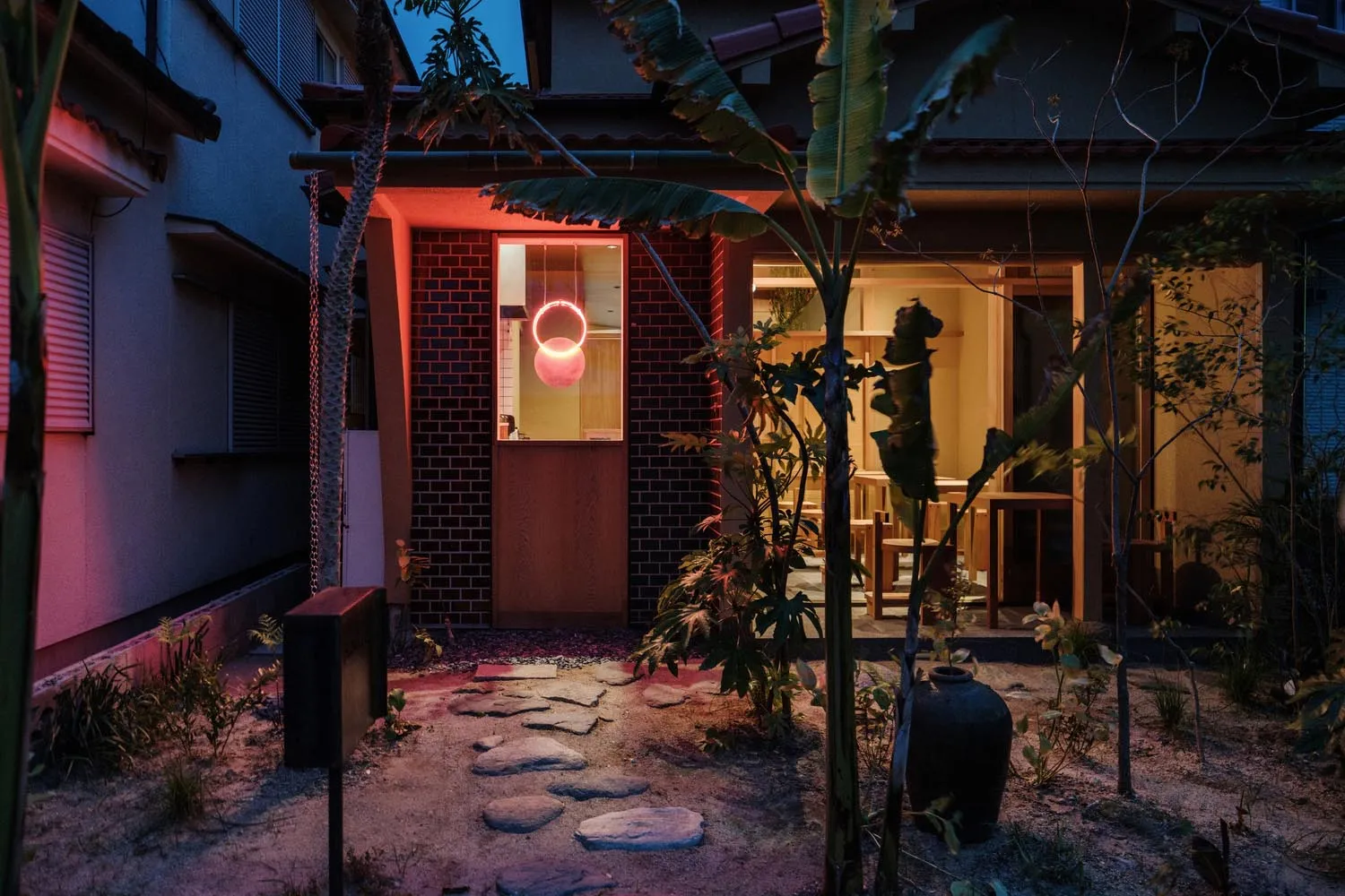 夜晚餐廳外觀，紅磚牆與混凝土結構搭配燈光照明。