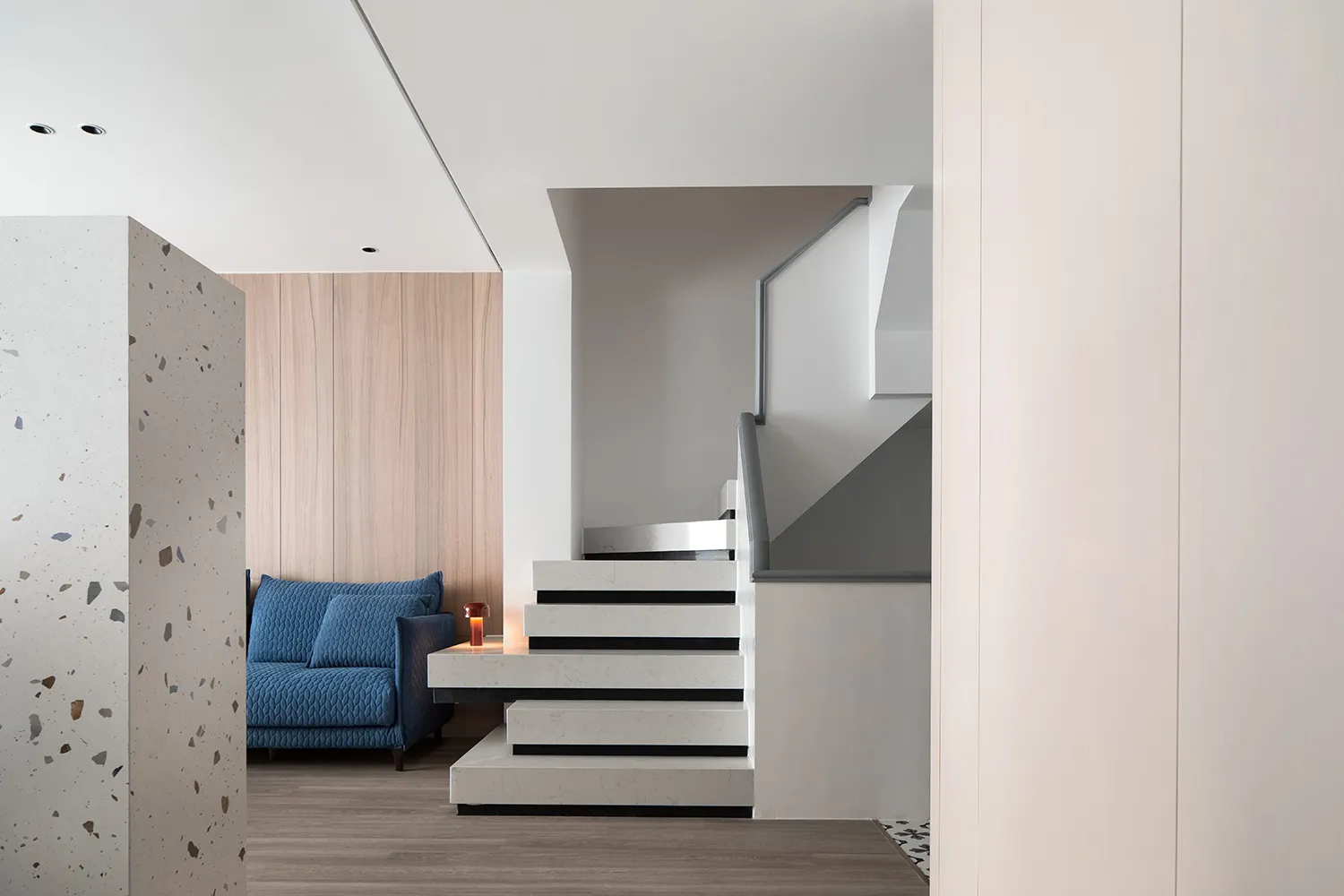 A modern industrial living space featuring terrazzo, concrete, and wood elements.