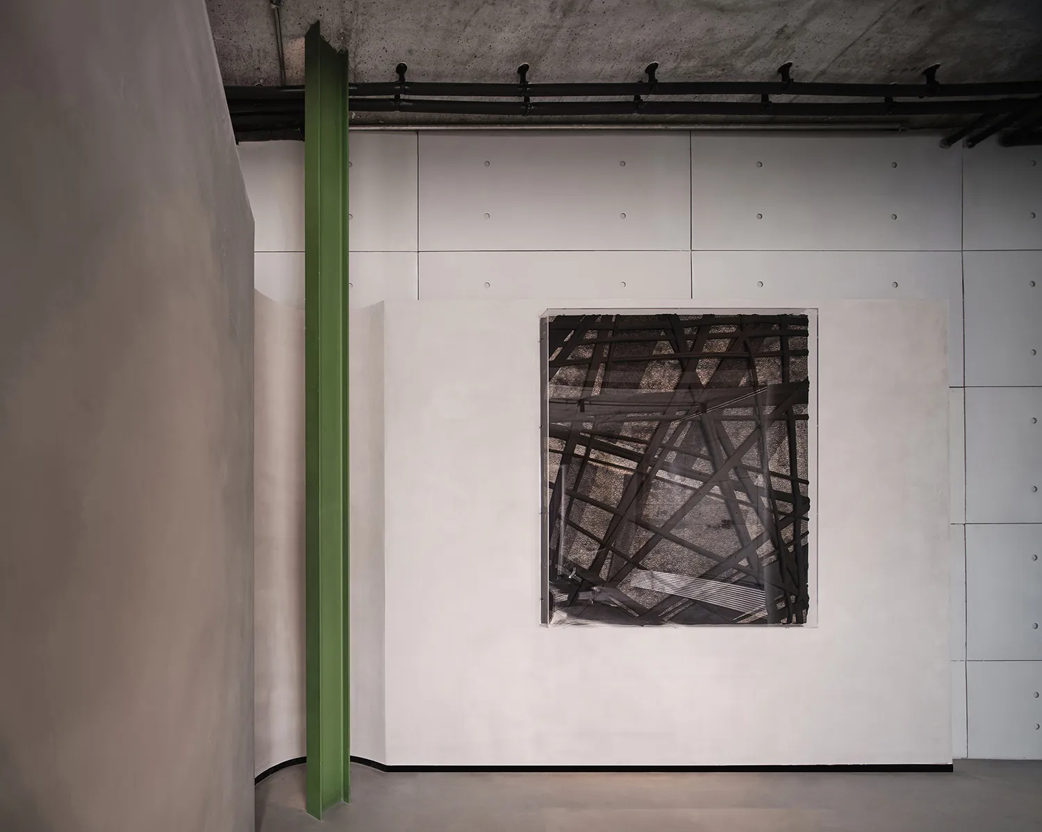 A minimalist metal-frame structure mounted on a white wall in an industrial-themed interior design setting.