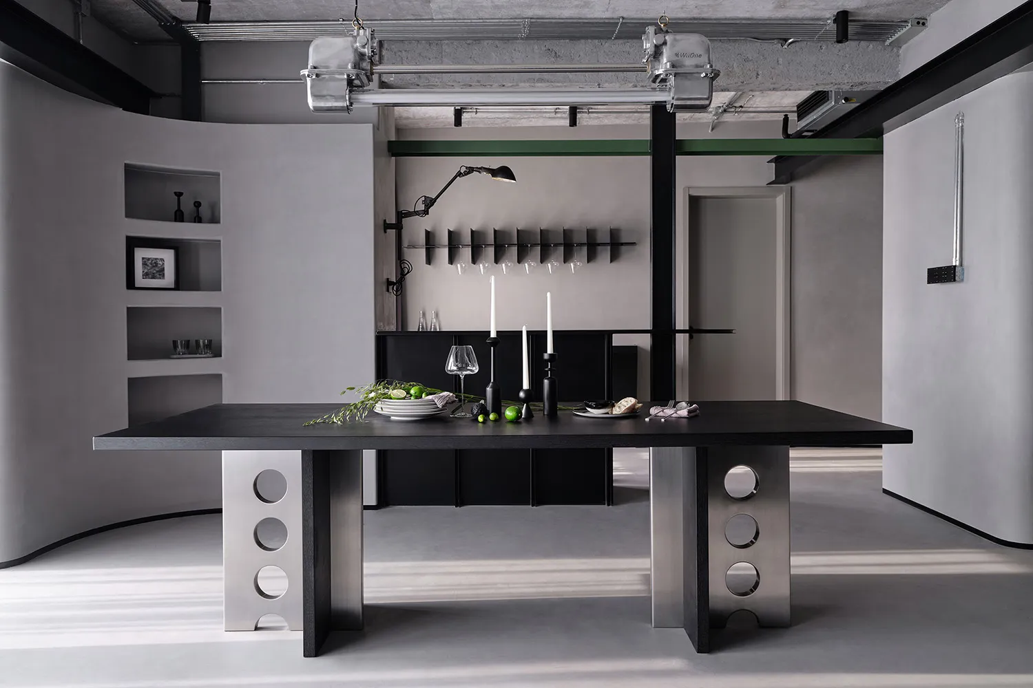 A modern minimalist dining room featuring a black metal table with a white background.
