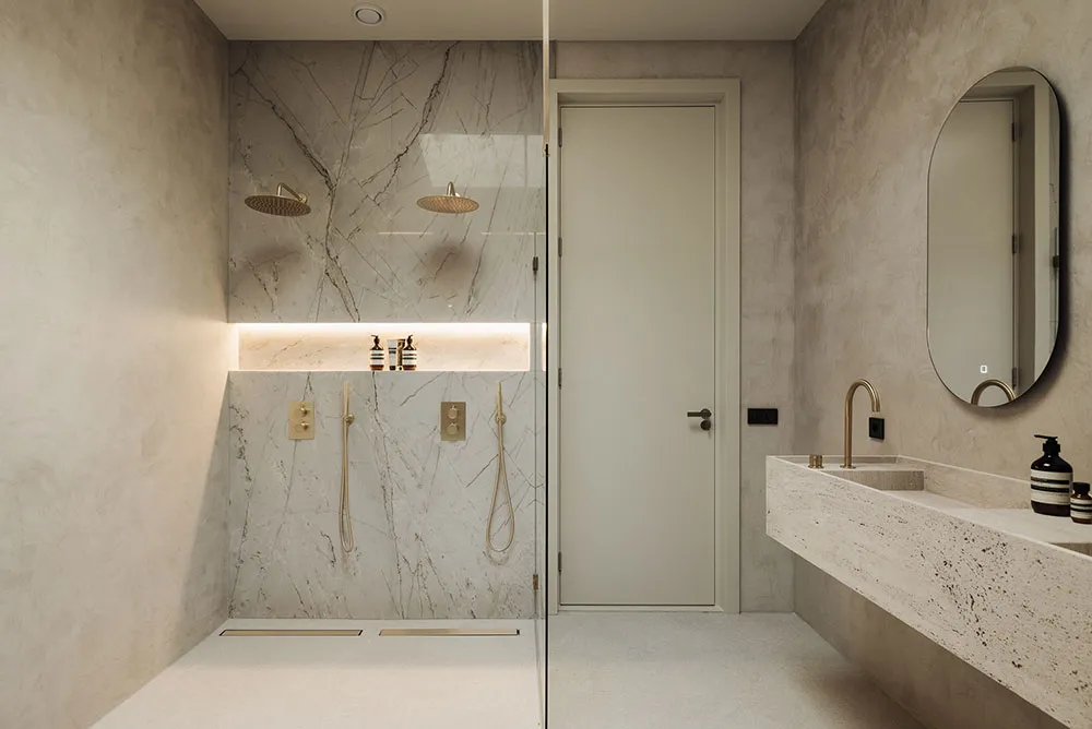 Modern minimalist bathroom with marble walls and cement floor