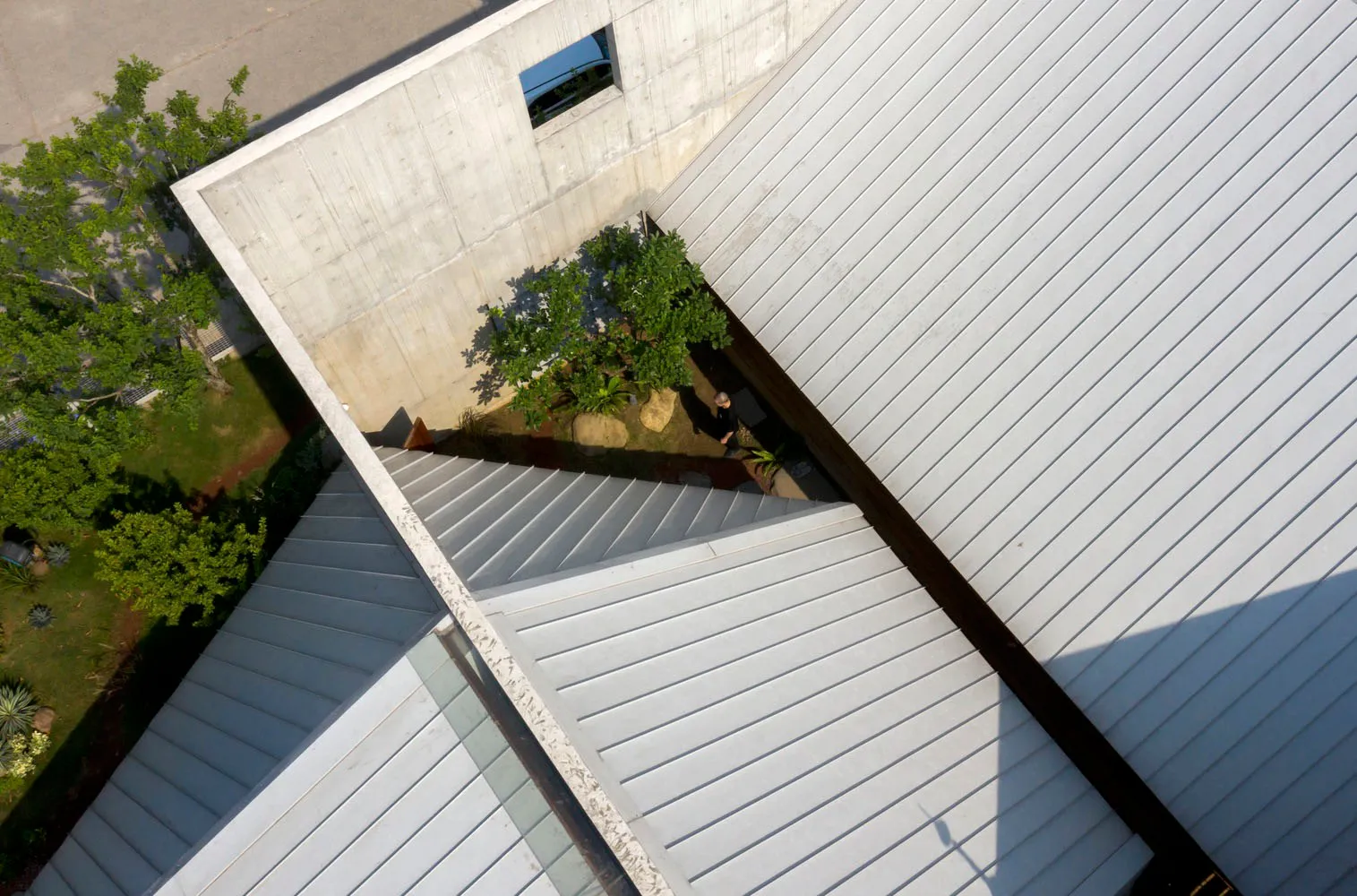 Top-down view of a modern building with a metallic roof and minimalist design.