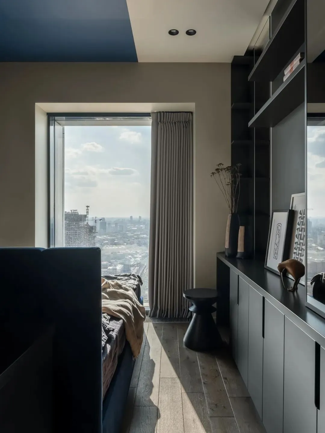 Minimalist bedroom with wooden bed, leather furniture, and industrial touches