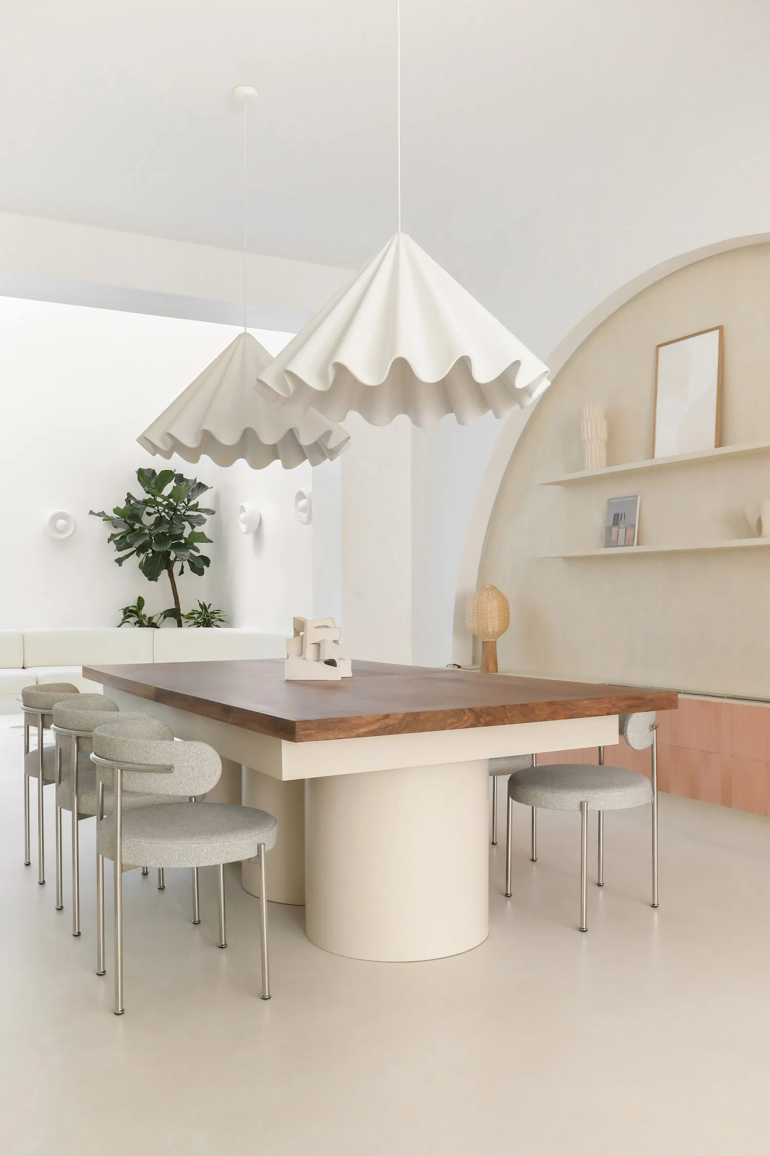A modern, minimalist interior design featuring a wooden table. The space is characterized by clean lines, neutral colors, and