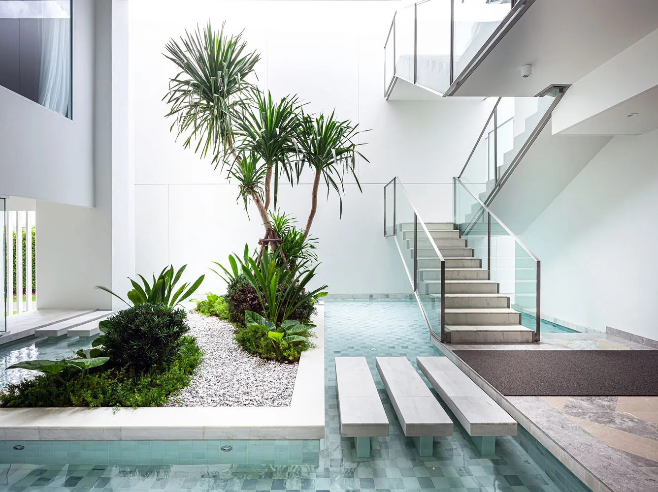 Modern staircase with glass railings and stone steps and landing