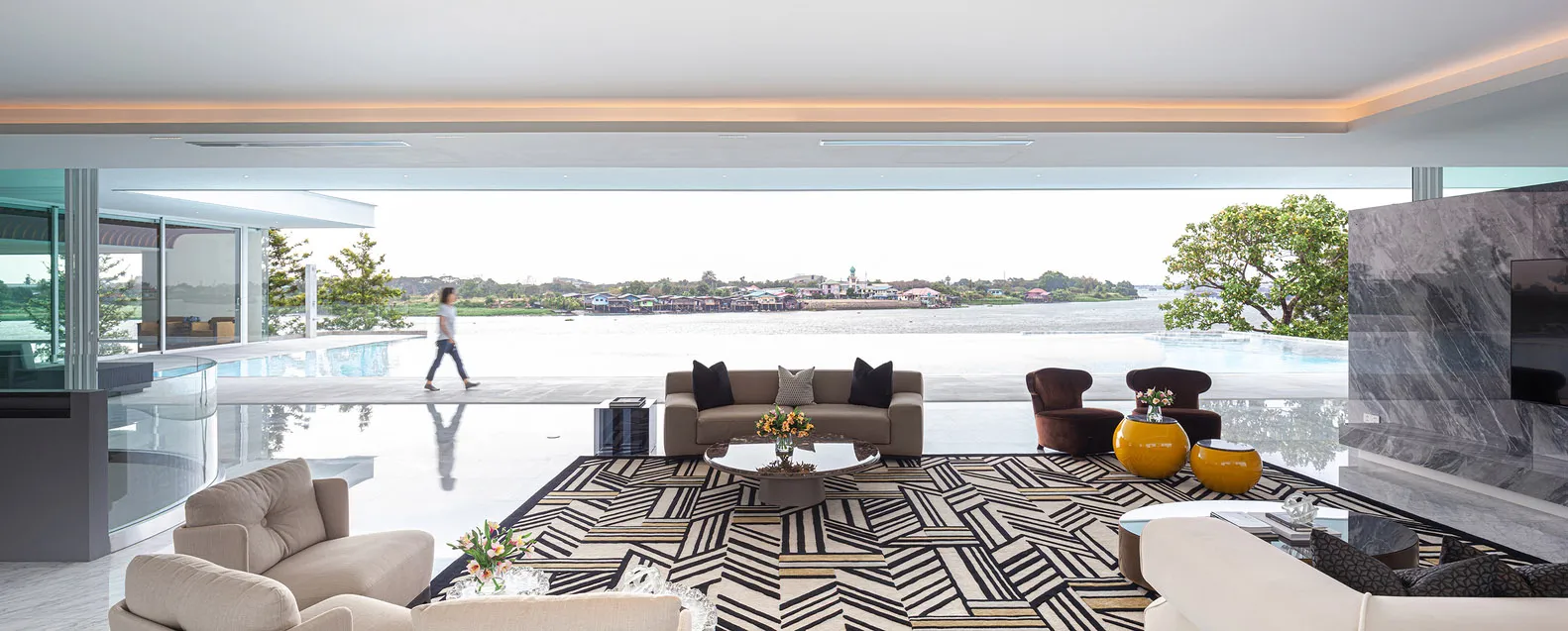 A modern living room with marble furniture and a geometric rug.