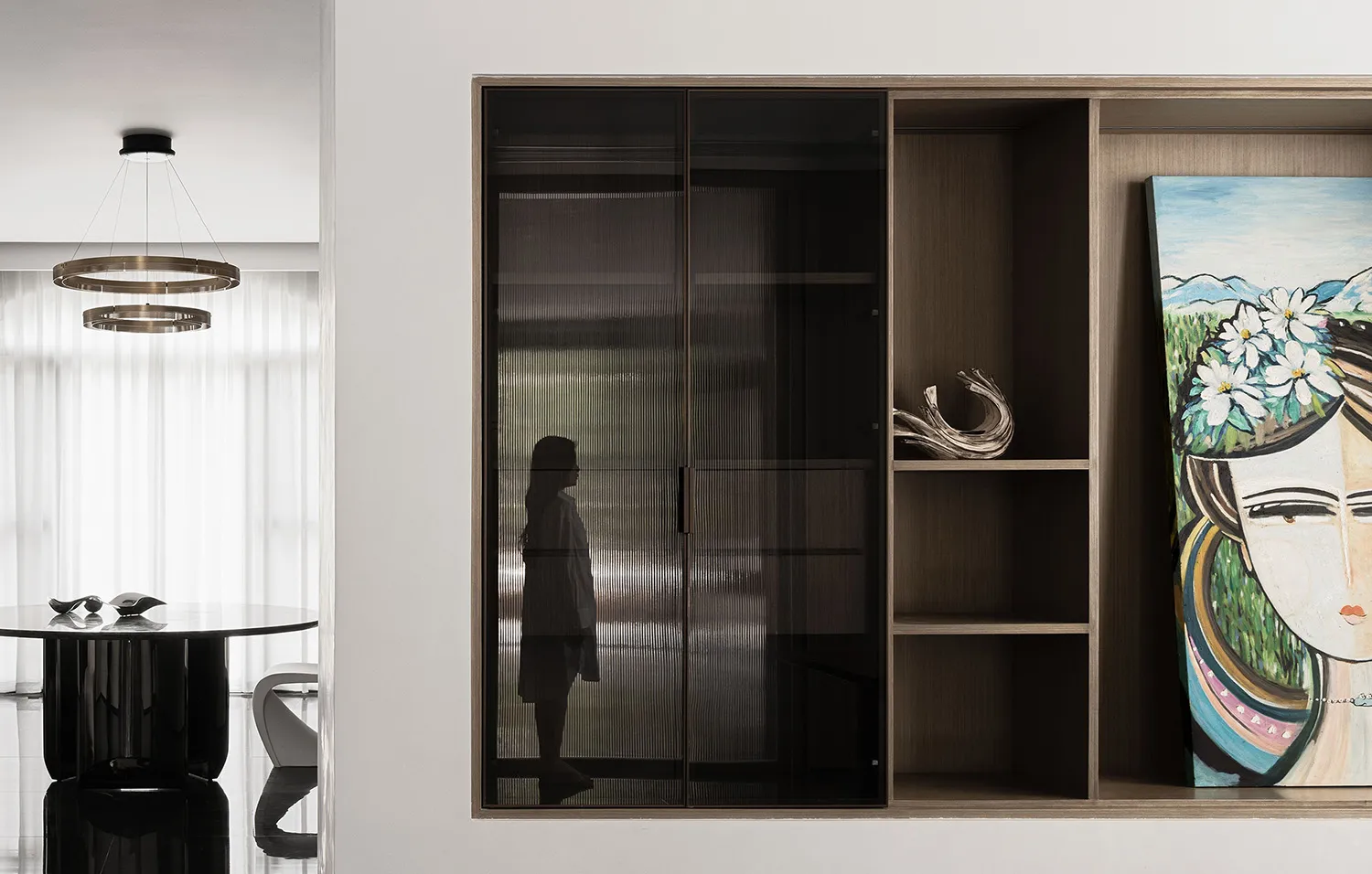 A modern living room featuring a sleek storage unit with glass doors and wooden accents.